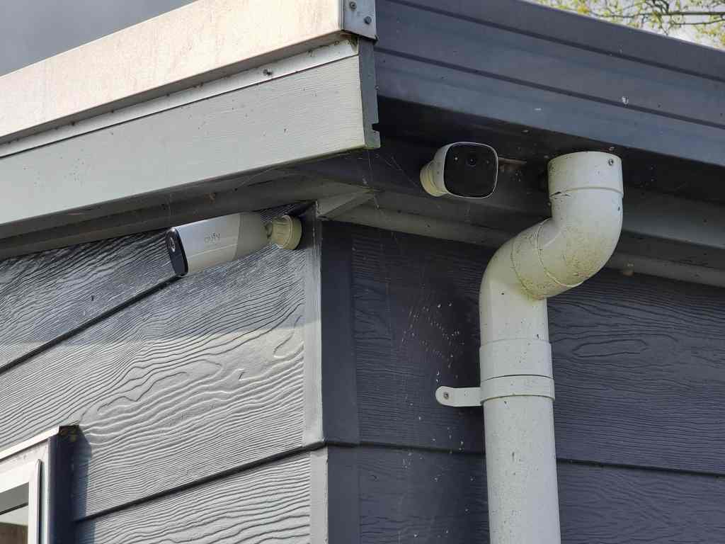 Picture of two wireless smart security cameras mounted on the wall of a shed